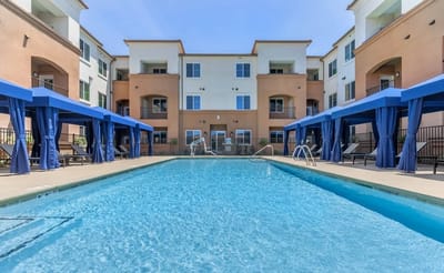 Swimming pool area with cabanas and building facade