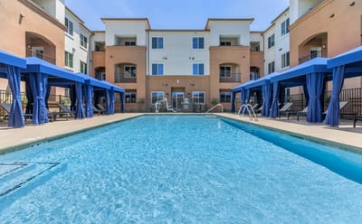 Outdoor pool area with cabanas and seating