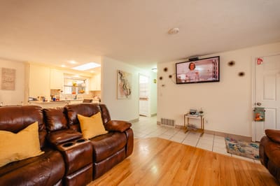 Cozy living room with a television and kitchen in the background