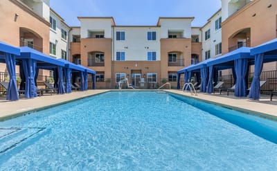 Swimming pool area with shaded cabanas