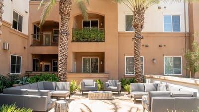Outdoor lounge area with seating and palm trees