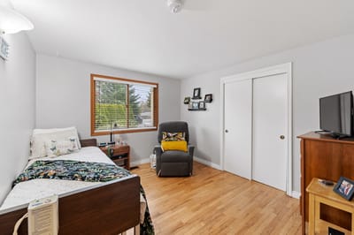 Cozy resident room featuring a bed and recliner