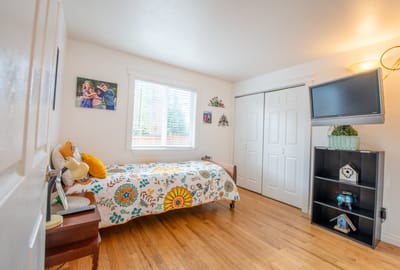 Cozy resident room with floral bedding and wooden floors