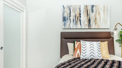 Cozy resident bedroom with decorative pillows and artwork