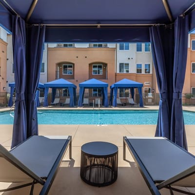 Outdoor pool area with lounge chairs and cabanas