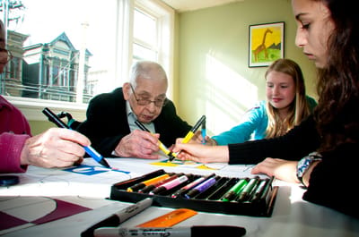 Residents and a volunteer engaging in art activity