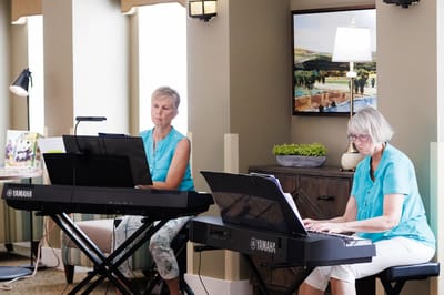 Residents playing music on keyboards in a recreational area