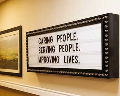 Sign displaying caring messages in a hallway