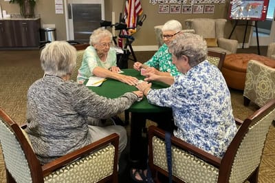 Residents engaged in a card game in the common area