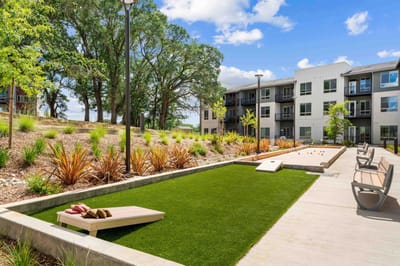 Outdoor area with lawn and seating near residential buildings