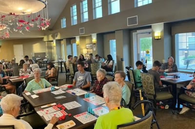 Residents playing bingo in a bright common area