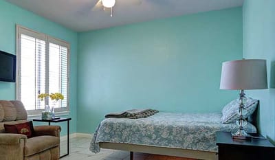Cozy resident room with blue walls and a bed