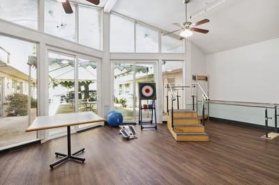 Rehabilitation gym with therapy equipment and natural light