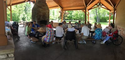 Residents enjoying a gathering at a shaded outdoor pavilion