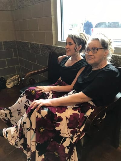 Two women in floral dresses sitting together