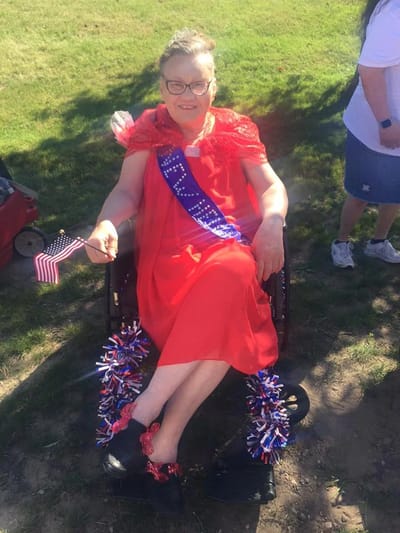 Resident celebrating with a small American flag at an outdoor event