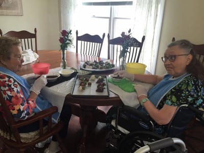 Residents engaging in a cooking activity at a dining table
