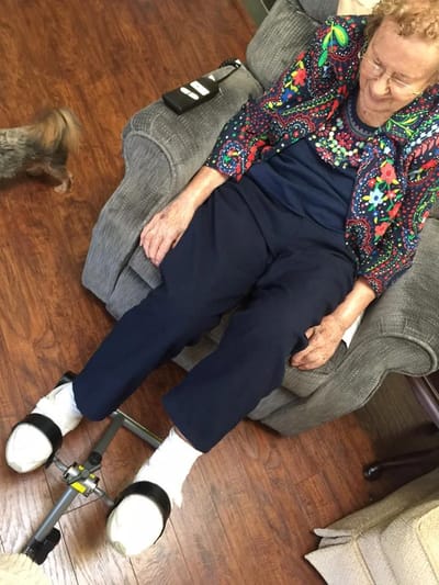 Resident seated with a small dog in a cozy lounge