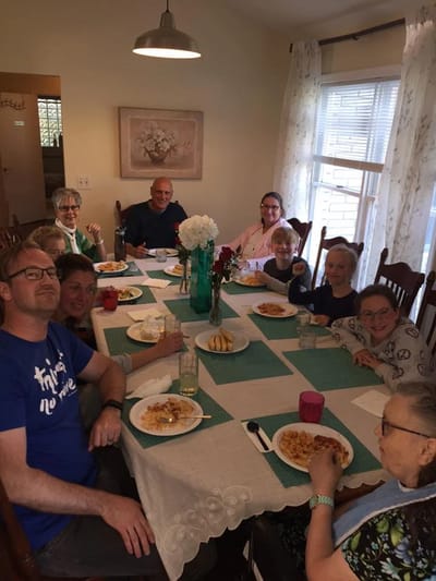 Residents and visitors enjoying a meal together at a dining table