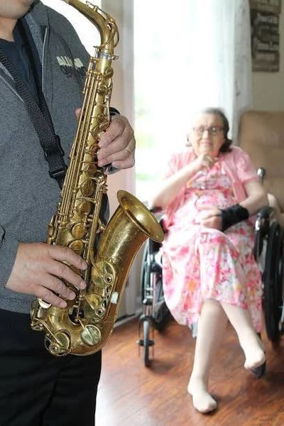 Resident enjoying a saxophonist performance indoors
