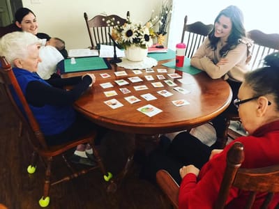 Residents and staff playing a game at a table