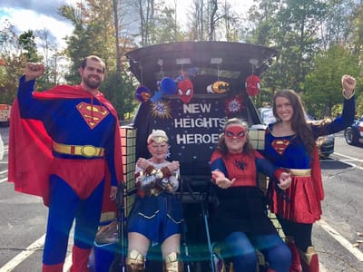 Residents and staff dressed as superheroes at an outdoor event