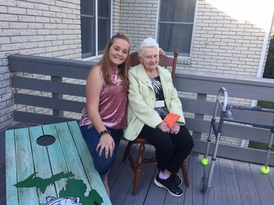 Resident and visitor enjoying time outdoors on a deck