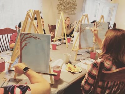 Residents participating in a painting activity indoors