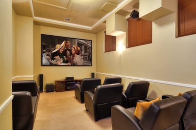 A cozy common area with chairs and a large screen