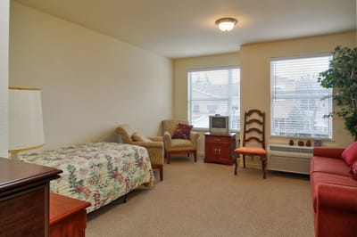 A cozy resident room with a bed and seating area