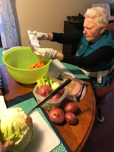 Resident preparing vegetables in a bright kitchen area