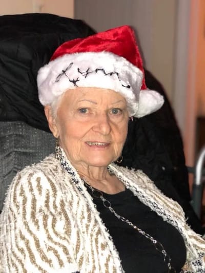 Resident wearing a Santa hat and smiling