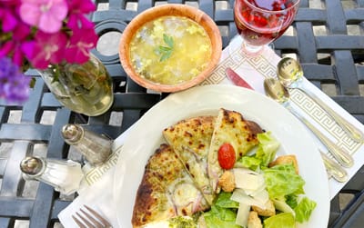 A plate of food with salad and soup outdoors