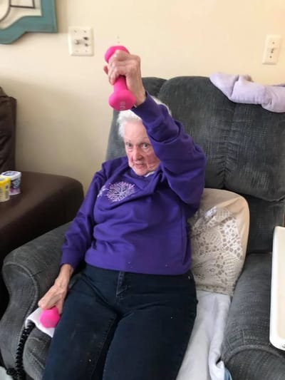 Senior resident exercising with pink weights