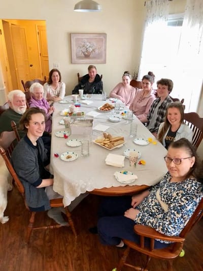 Residents and staff enjoying a meal together at a dining table