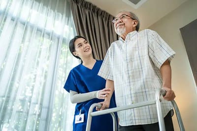 Staff assisting a resident with a walker