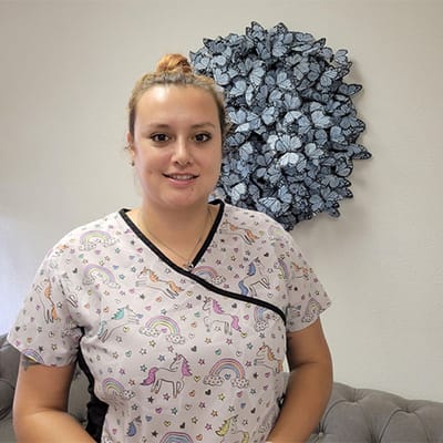 Staff member in colorful scrubs with wall art