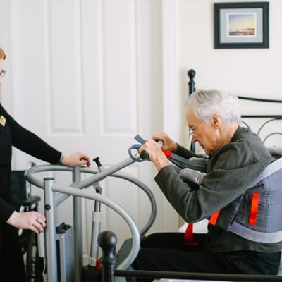 A staff member assisting a resident with mobility equipment