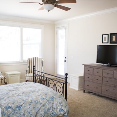 Cozy bedroom setup with seating and a TV