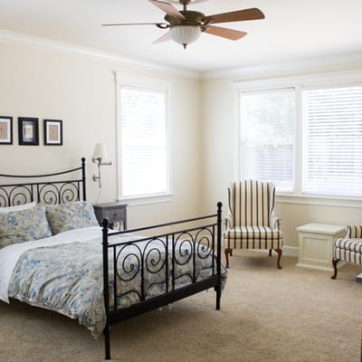 Bright interior of a resident bedroom with a bed and seating area.