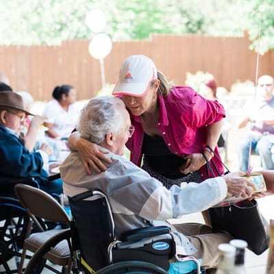 A staff member interacting with a resident outdoors at a celebration
