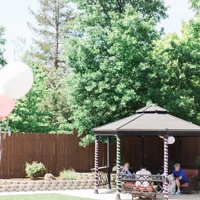 Residents enjoying time under a gazebo in the garden