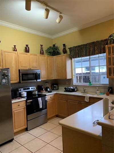 A well-lit kitchen with wooden cabinetry and appliances
