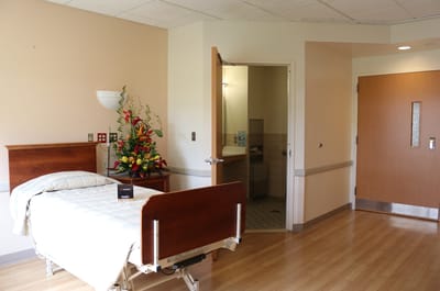 A spacious resident room with flowers and bathroom