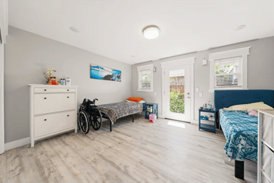 Bright private resident room with beds and wheelchair