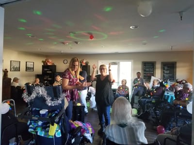 Residents enjoying a lively activity with staff in a common area
