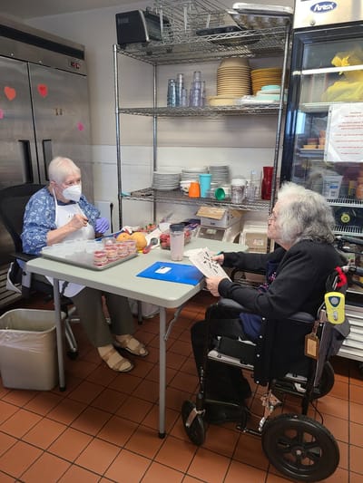Staff assisting a resident in a kitchen area