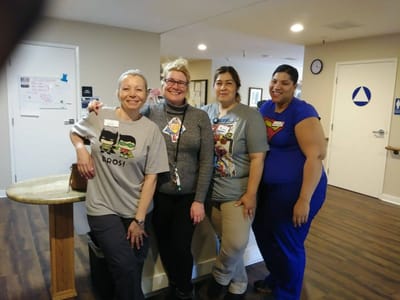 Staff members posing together in a bright hallway