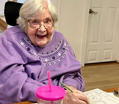 Senior resident happily coloring in a common area