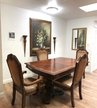 Dining room with wooden table and floral artwork on wall